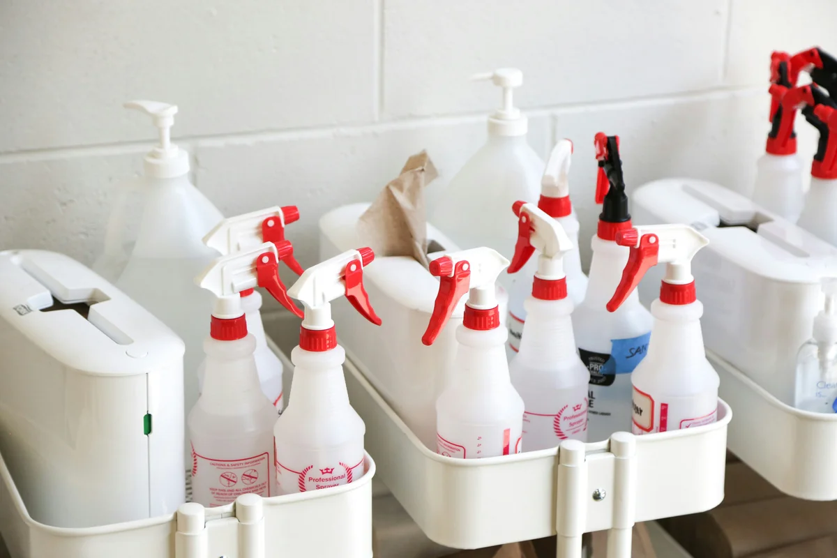 white plastic bottles on white plastic container - beginner guide to buying nontoxic cleaning supplies