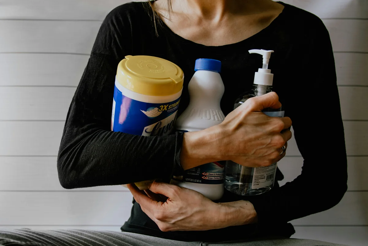 Woman gathering cleaning supplies - best alternative products to mainstream household giants