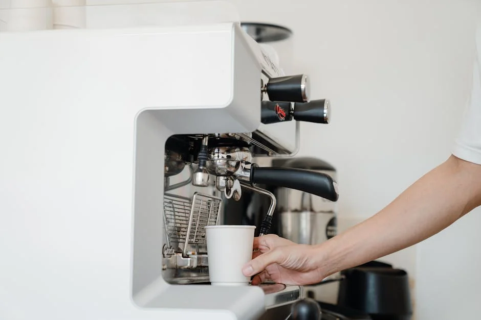 Person's hand using an espresso machine to prepare coffee. Modern kitchen setting. - how to choose the right coffee maker for your morning routine