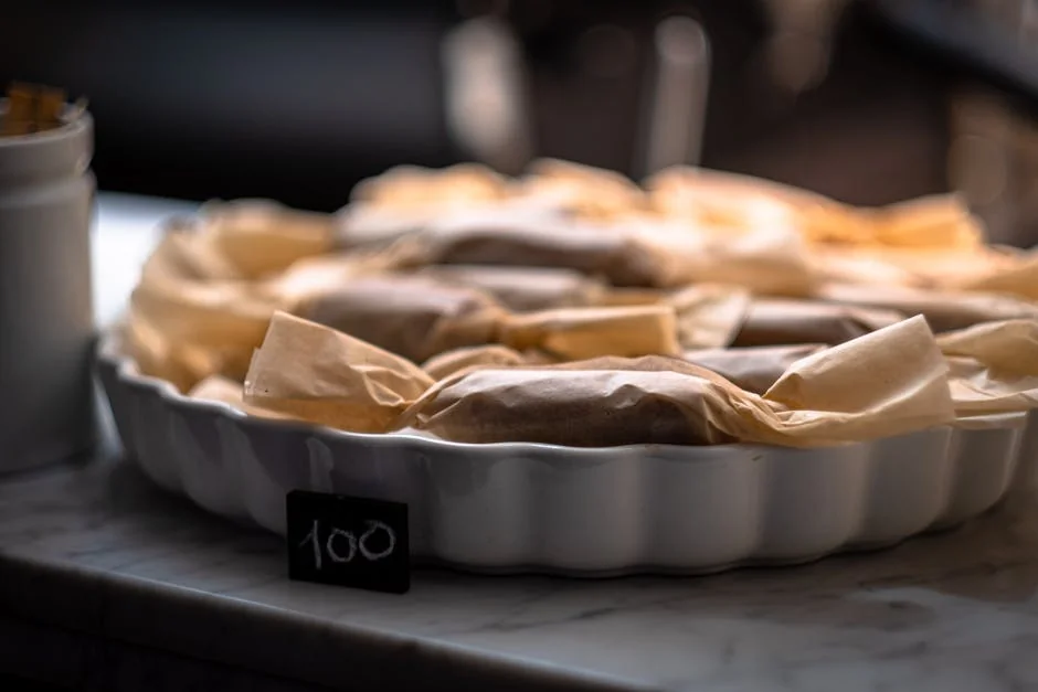 A tray of wrapped pastries with a price tag displayed in a cozy bakery setting. - discovering highquality artisanal daily goods at fair prices