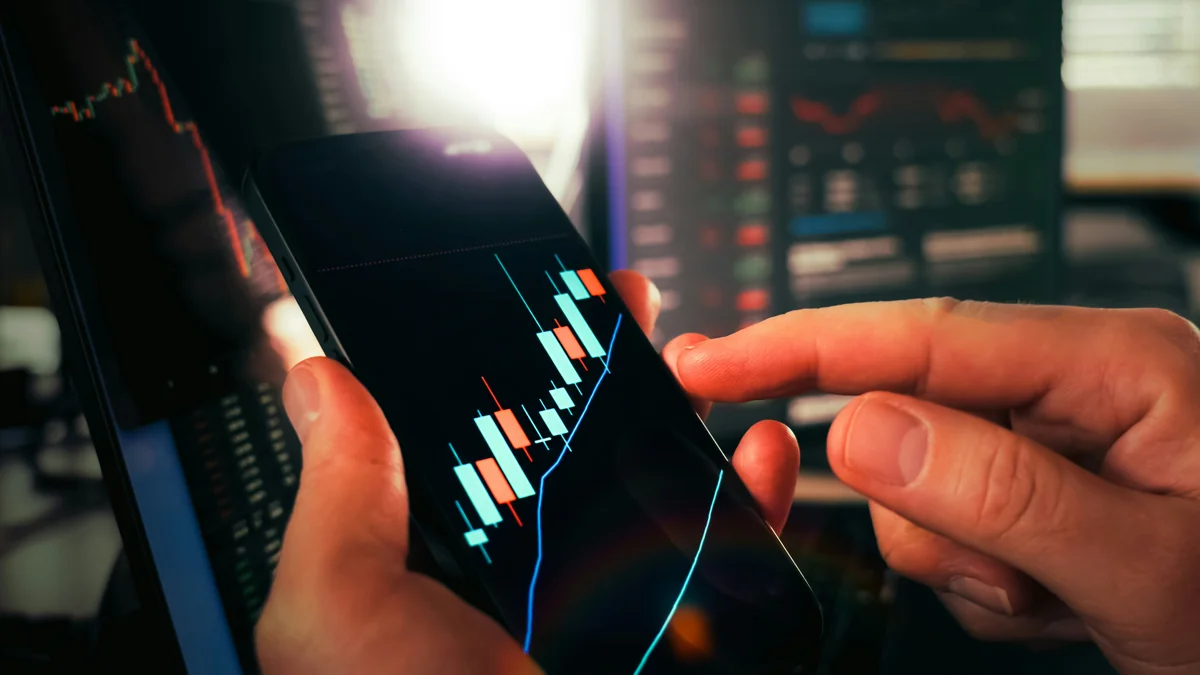 Cryptocurrency trading analysis mobile chart growth candlesticks. Close-up of hands analyzing bullish candlestick patterns on smartphone - financial growth portfolio - Are expensive daily products worth the investment
