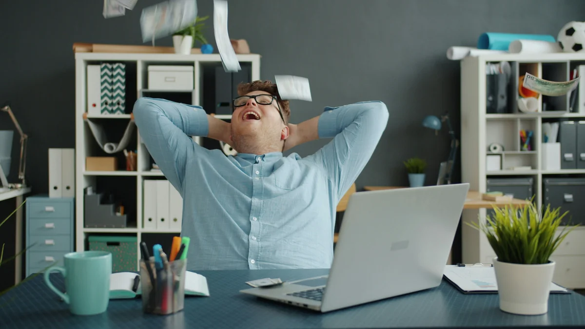lots of money falling on handsome guy in office sitting at desk alone enjoying wealth. Happiness, rich youth and financial luck concept. - financial growth portfolio - Are expensive daily products worth the investment