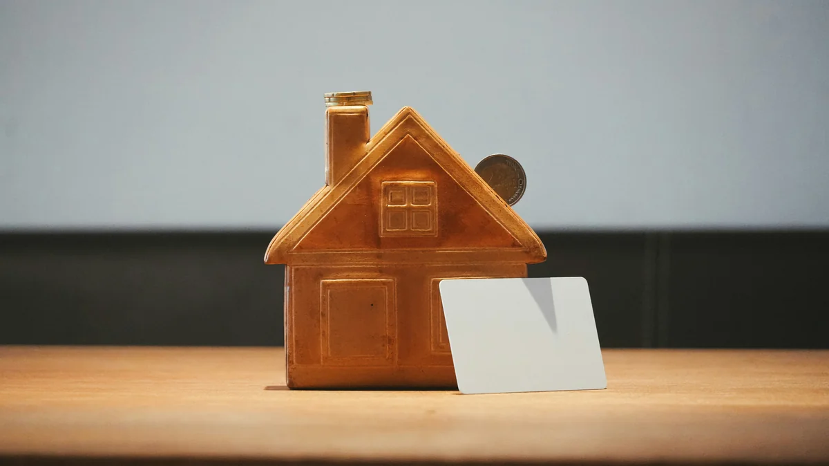 A small house bank with a coin and blank card. - financial growth portfolio - Are expensive daily products worth the investment