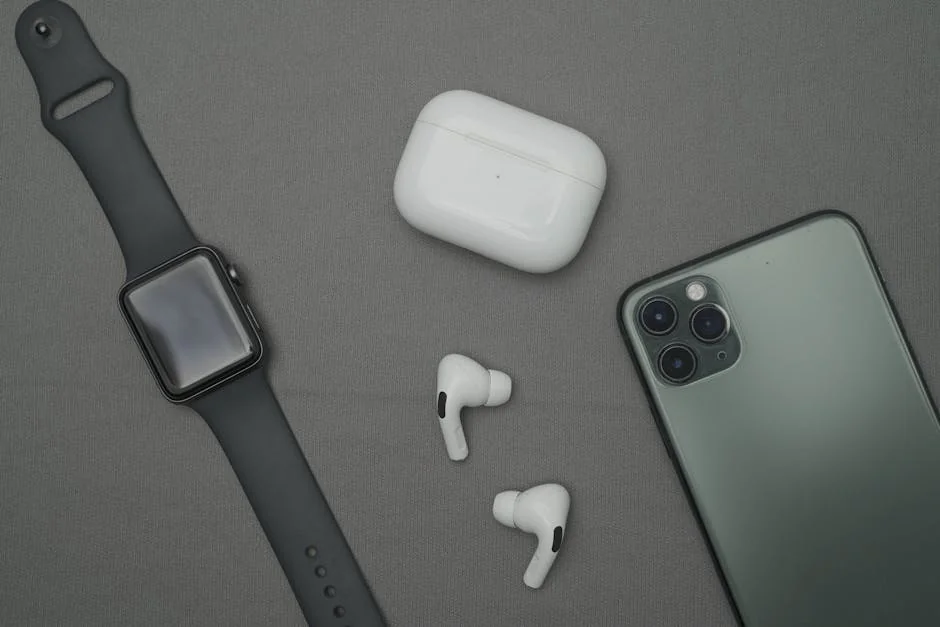 Flat lay of smartwatch, smartphone, and wireless earbuds on a gray background. - factors to consider before upgrading your daily tech gadgets