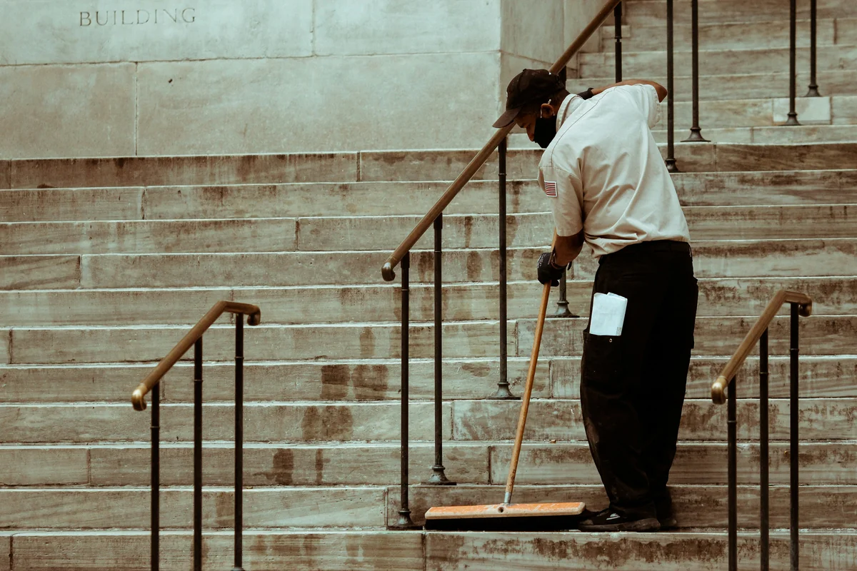 man in white dress shirt and black pants standing on brown wooden ladder - highperformance cleaning tools for busy professionals