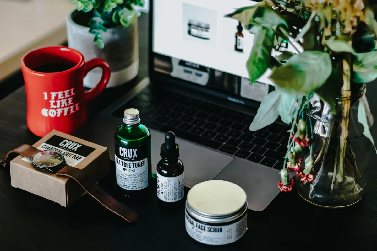 two labeled glass bottles beside turned-on grey laptop computer - highquality selfcare products for an improved daily routine