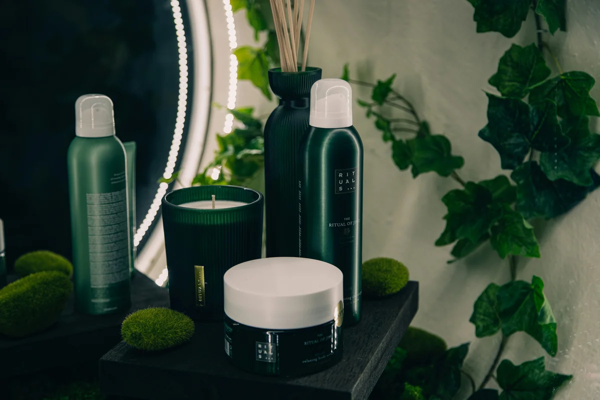 a table topped with bottles and candles next to a mirror - highquality selfcare products for an improved daily routine