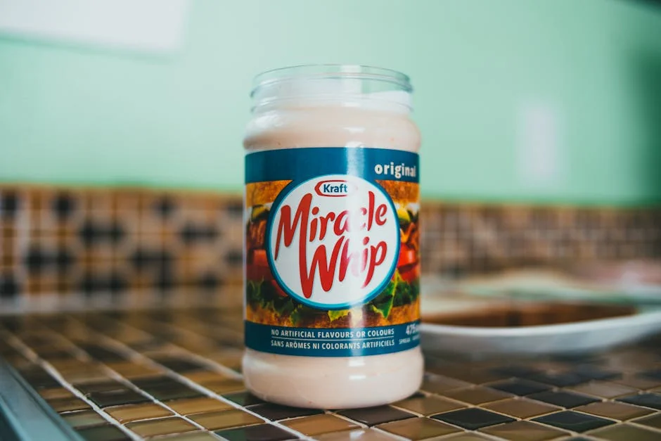 A close-up shot of a Miracle Whip jar on a kitchen counter with a blurred background. - honest comparison of premium vs generic household brands
