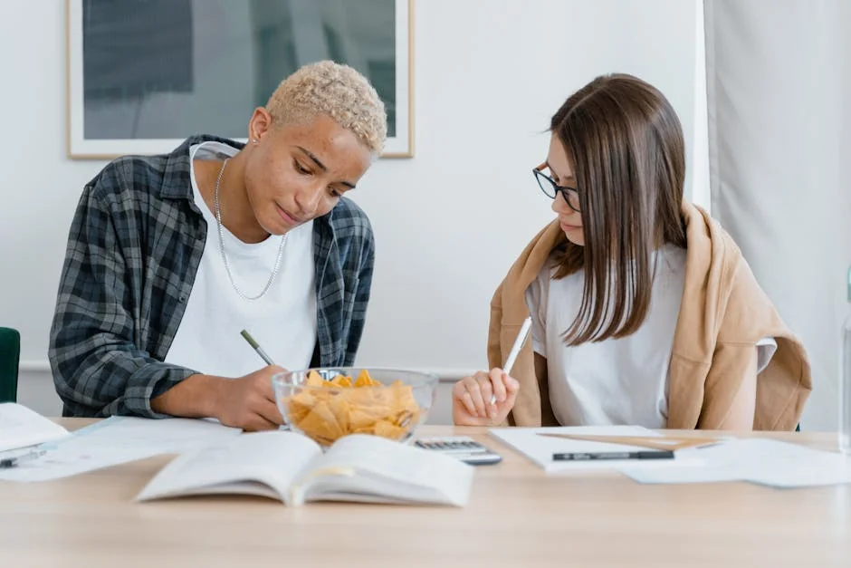 Two college students studying indoors, focusing on writing and homework tasks. - musthave daily goods for college students in dorms
