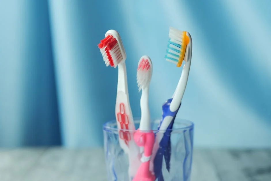 A trio of vibrant toothbrushes in a glass on a blue background, emphasizing dental hygiene. - performance analysis of the top electric toothbrushes