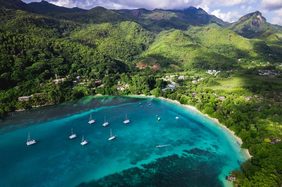 Stunning aerial shot of Beau Vallon Bay's turquoise waters, lush greenery, and anchored boats in Seychelles. - adventure vacation destination - Rare and useful travel essentials for frequent commuters