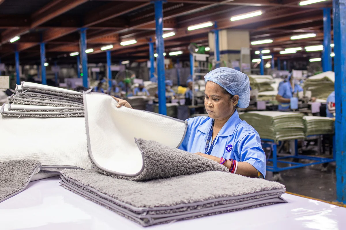 Woman working in a textile factory inspecting products. - how to spot highquality materials in everyday household goods