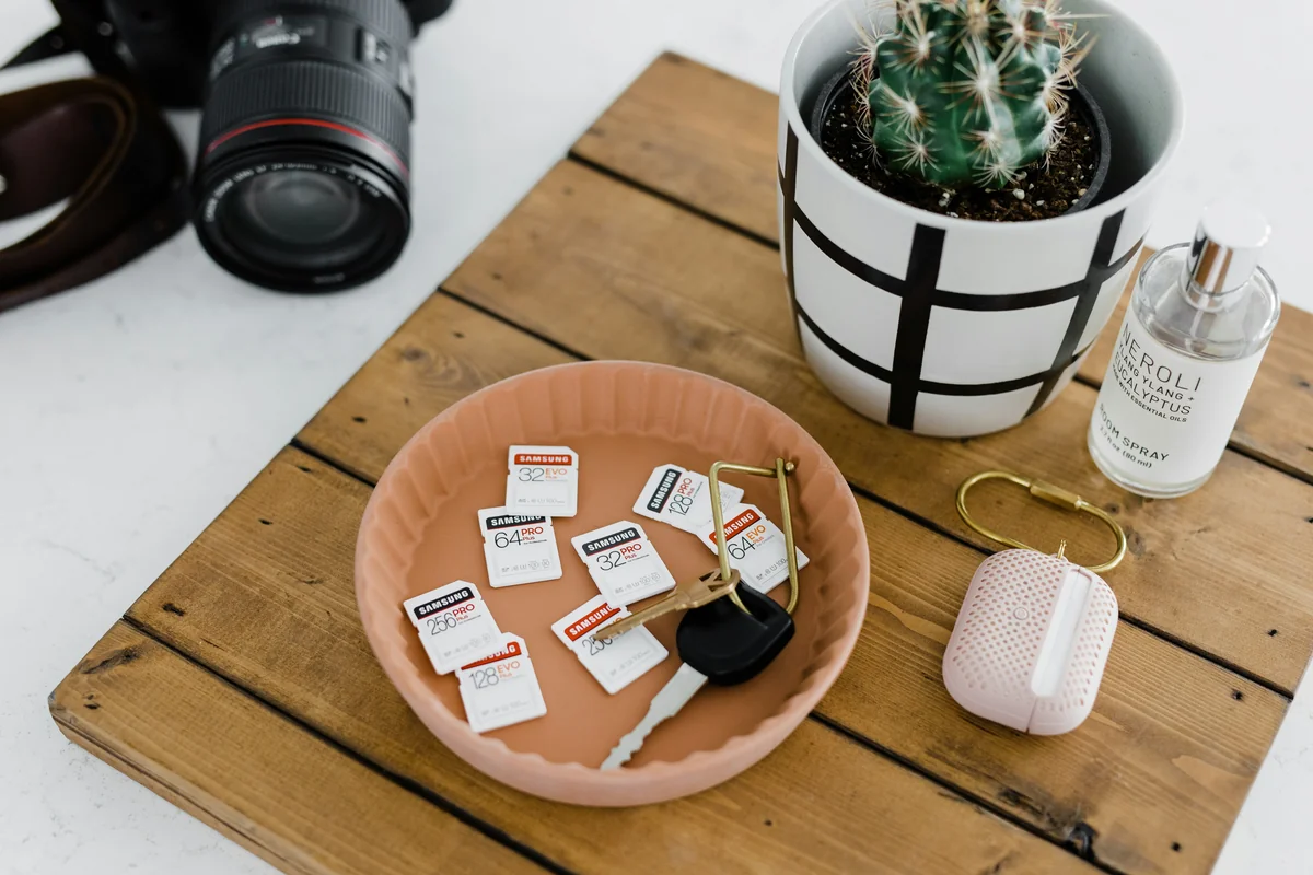 black dslr camera on brown wooden round tray - top minimalist daily products for a clutterfree life