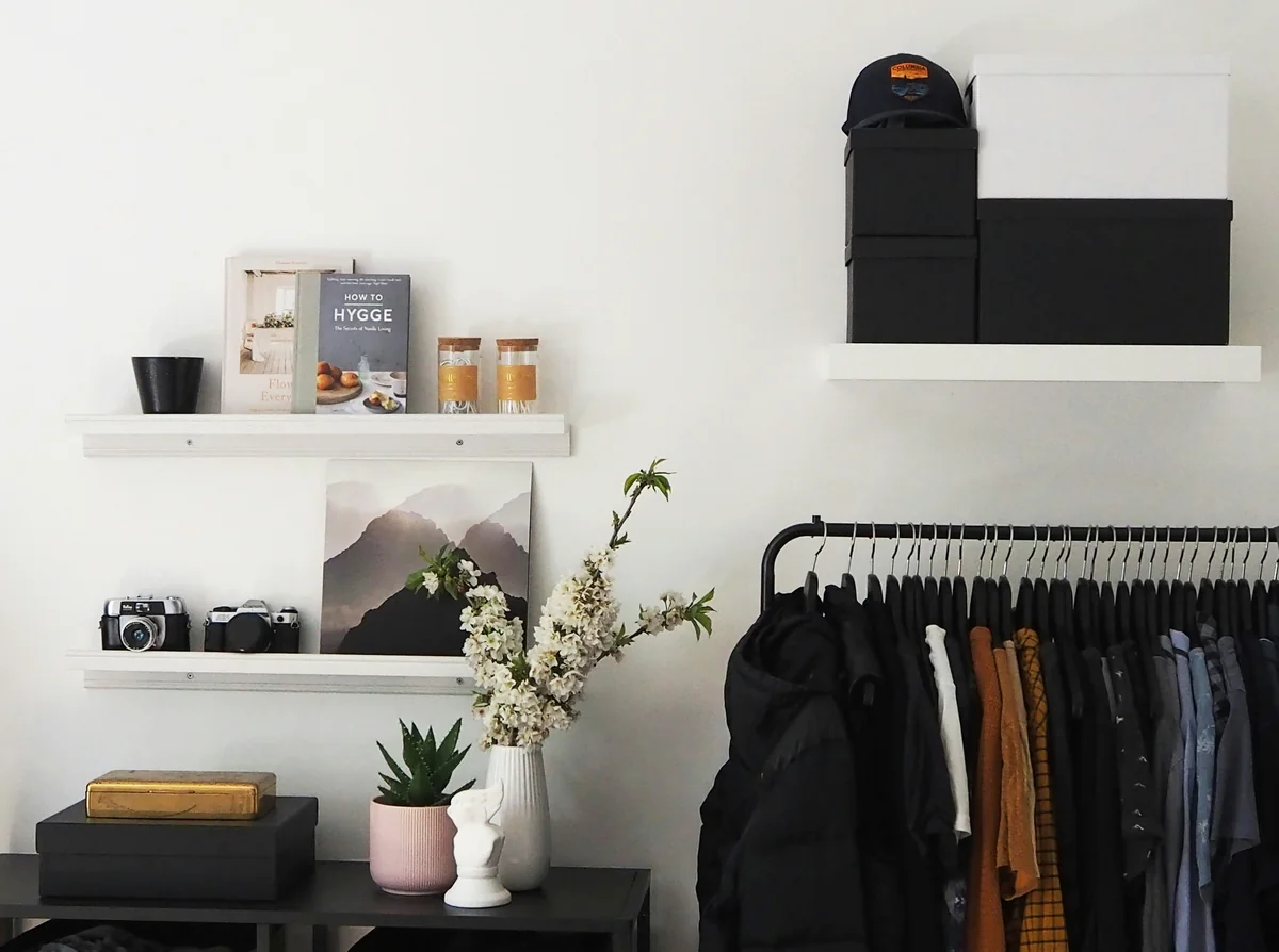 capsule wardrobe, books, shelves, clothes, cameras, boxes, female clothes, pink pot, flowers, gold box, boxes, black box, cloths rail - top minimalist daily products for a clutterfree life