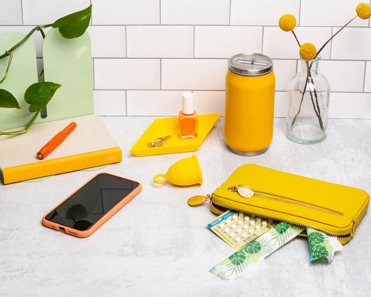 a table topped with a cell phone and a yellow case - top minimalist daily products for a clutterfree life