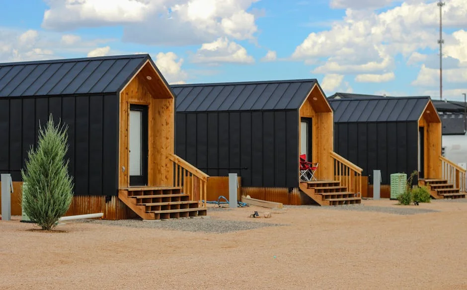 Row of modern black tiny houses in a desert setting under a cloudy sky. - top spacesaving gadgets for tiny house living