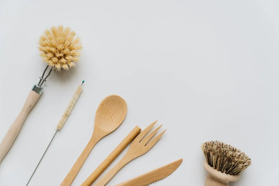 Flat lay of wooden kitchen utensils and brushes promoting eco-friendly lifestyle and sustainability. - ultimate buying guide for sustainable kitchenware