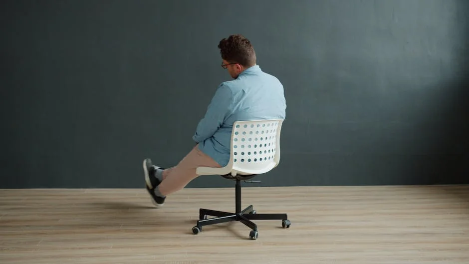Rear view of a man spinning on a swivel chair in a minimalist interior setting. - user experience report on ergonomic dailyuse furniture
